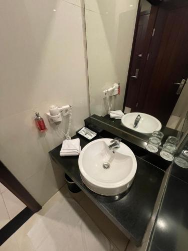 a bathroom with a sink and a mirror at Samara Resort in Batu