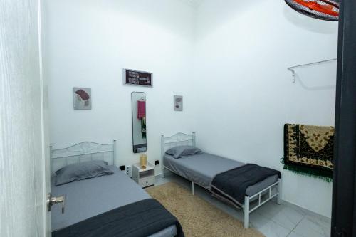 a room with two beds in a room at Akiera Homestay #MELAYU ONLY in Pelabohan Klang