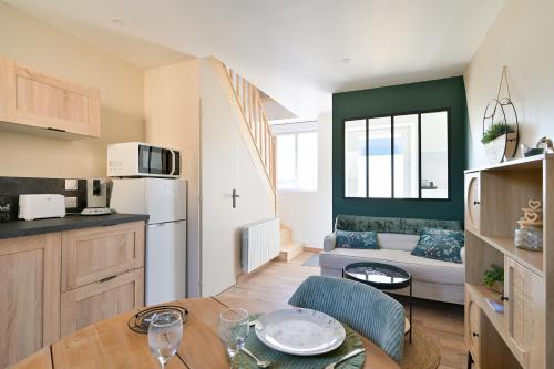 Il dispose d'une cuisine et d'un salon avec une table et un canapé. dans l'établissement Le petit mannevillettais, à Mannevillette