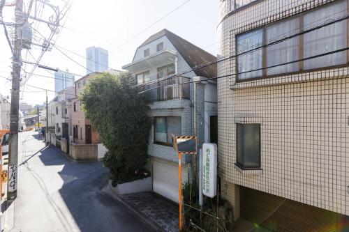 an empty street next to a brick building at 楽宿 Nishi Shinjuku 017T in Tokyo