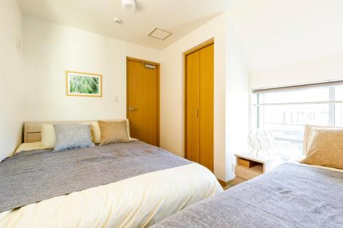Postel nebo postele na pokoji v ubytování 017T 楽宿 Nishi Shinjuku Y'sINNグループ西新宿1 西新宿の築浅3階建4DK 駅近10分 各階WiFi 閑静 机あります