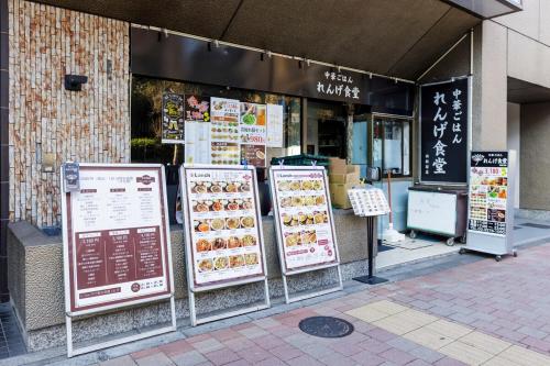 a restaurant with signs in front of a store at 楽宿 Nishi Shinjuku 017T in Tokyo