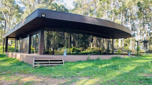 a pavilion in the middle of a field with trees at Luxury Evergreen Escape in Musk