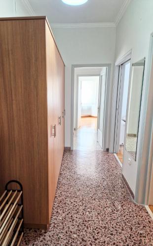an empty room with a wooden cabinet and a hallway at EstellApartments in Athens