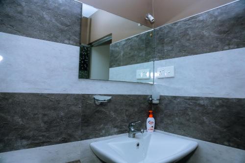 a bathroom with a sink and a mirror at Evergreen Cottage in Mirissa