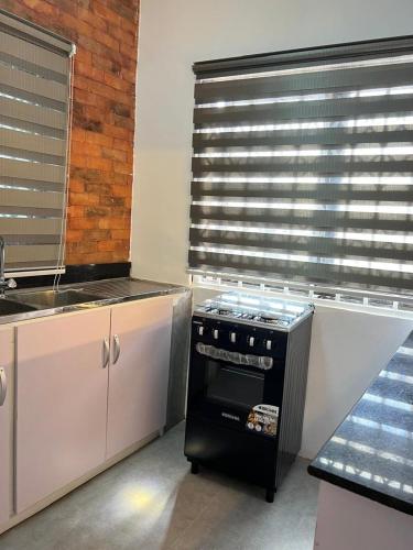 a kitchen with a black stove and a window at Ayaa Grace in Accra