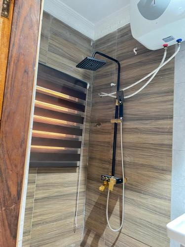 a shower in a room with a wooden floor at Ayaa Grace in Accra