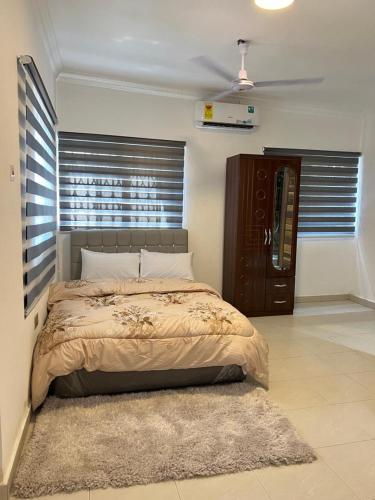 a bedroom with a bed and a window and a rug at Ayaa Grace in Accra