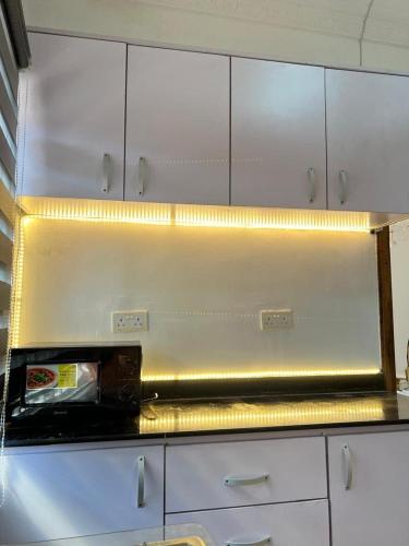 a kitchen with a counter top with lights on it at Ayaa Grace in Accra