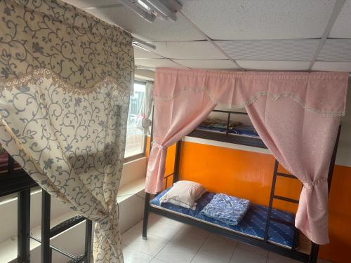 a bunk bed in a room with a curtain at HappyHealingHeaven in Hengchun