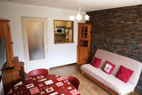 un salon avec un canapé et un mur de briques dans l'établissement Résidence Orr Des Neiges - GRAND APPARTEMENT 6 PERSONNES MAE-3954, à Le Mélézet