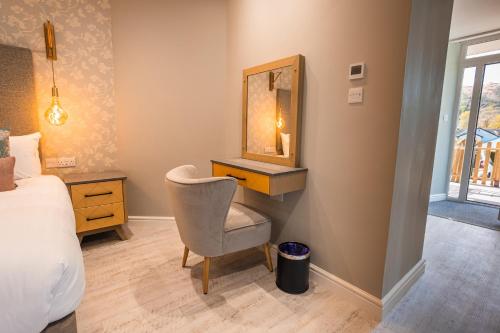 a bedroom with a bed and a mirror and a chair at Ambleside Townhouse in Ambleside