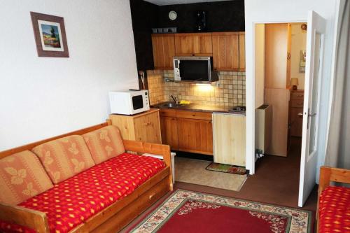 un salon avec un canapé et une cuisine dans l'établissement Résidence Orr Des Cimes - Studio 4 personnes vue pistes MAE-4004, à Le Mélézet