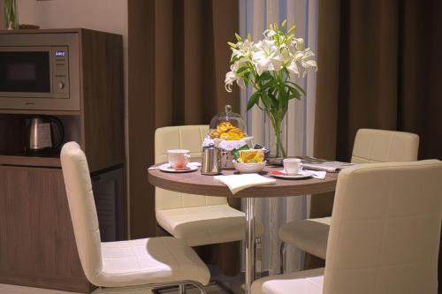 - une salle à manger avec une table, des chaises et des fleurs dans l'établissement Hotel Marcantonio, à Rome