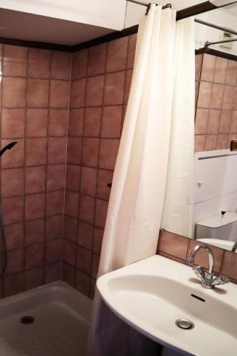 une salle de bain avec un lavabo et un rideau de douche dans l'établissement Résidence Le Cairn - STUDIO N° 0309 LE CAIRN MAE-4511, aux Orres