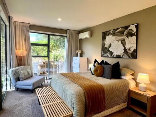 a bedroom with a bed and a chair and a window at 5-Star Boutique Retreat! Hot pool! Amazing view! in Queenstown