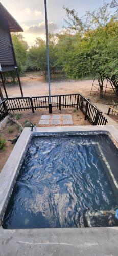 a large pool of water in front of a house at Amare Cabin in the bush with all your needs! in Marloth Park