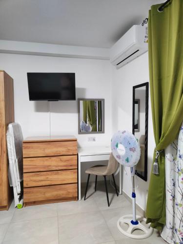 a room with a desk and a tv and a chair at Infinity view residence in Sannat