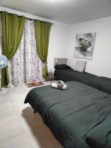 a bedroom with two beds and green curtains at Infinity view residence in Sannat