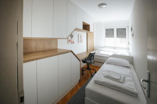 a small room with a bed and a desk at Superbia Osijek - SELF CHECK-IN in Osijek