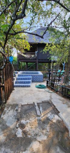 a patio with a blue bench in front of a house at Amare Cabin in the bush with all your needs! in Marloth Park
