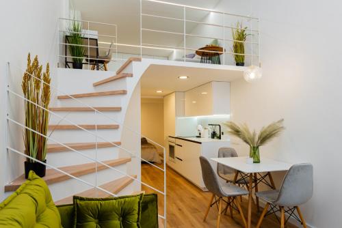 a staircase in a living room with a table and chairs at Palanga Suites in Palanga