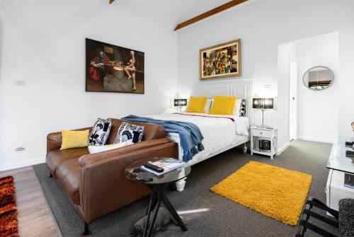 a bedroom with a bed and a couch at Cordwainer Eco Studio in Deloraine