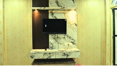 a bathroom with a tv on top of a marble counter at Ganga Riverfront Rooms And Banquet in Prayagraj