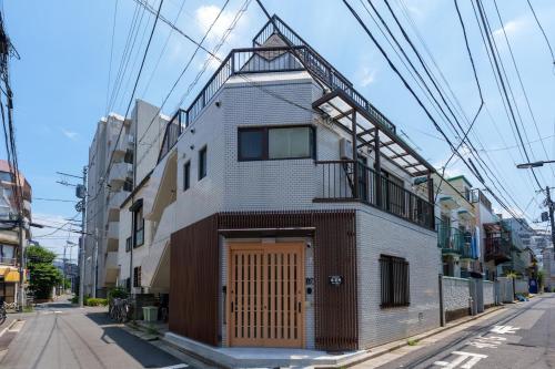a building with a wooden door on a street at 楽逸グループ 池袋瑞月苑2F 111Tb in Tokyo