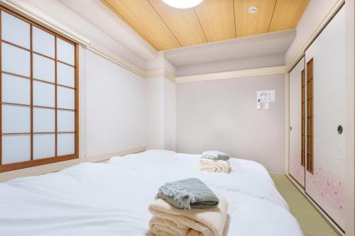 a room with a bed with towels on it at 楽逸グループ 池袋瑞月苑2F 111Tb in Tokyo