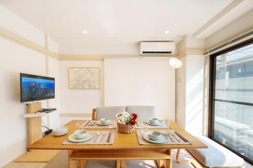 a dining room with a table and a tv at 楽逸グループ 池袋瑞月苑2F 111Tb in Tokyo
