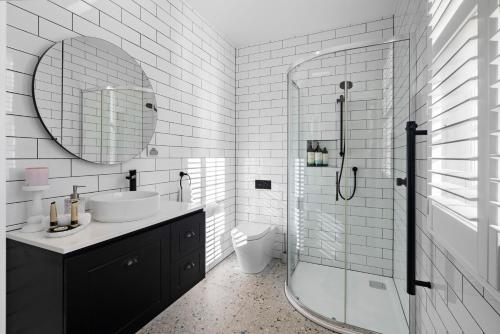 a white bathroom with a sink and a shower at Cordwainer Eco Studio in Deloraine