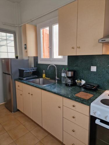 a kitchen with a sink and a refrigerator at EstellApartments in Athens