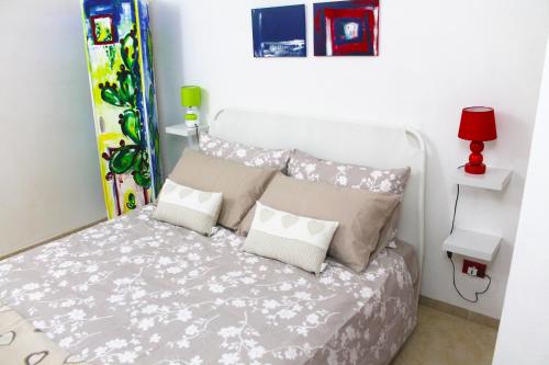 a small bedroom with a bed with pillows at Ariel Apartment Ortigia Siracusa in Siracusa