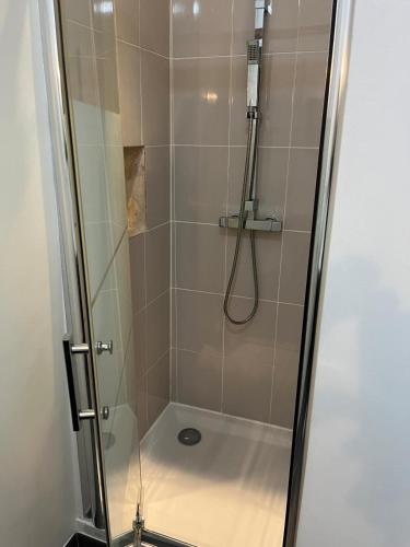 une cabine de douche avec une porte en verre et une douche. dans l'établissement Le Contemporain, à Rochefort