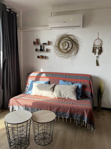 - un salon avec un lit et deux tables dans l'établissement Studio à 50 m de la plage, wifi, climatisation 2HOU34, à Canet