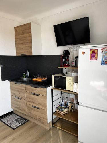 - une cuisine avec un réfrigérateur blanc à côté d'un comptoir dans l'établissement Studio à 50 m de la plage, wifi, climatisation 2HOU34, à Canet