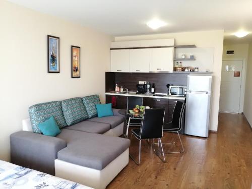 ein Wohnzimmer mit Sofa und eine Küche in der Unterkunft Apartments Atia Resort in Tschernomorez