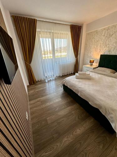 a bedroom with a large bed and a large window at Sofia Residence Apartments Cetate in Târgu Neamț