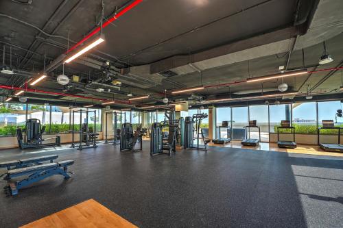 a gym with benches and machines in a room with windows at Capital Suites Hotel Apartments in Abu Dhabi