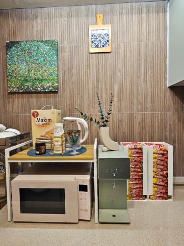 a kitchen with a table with a microwave and acomputer at Space Stay in Seoul