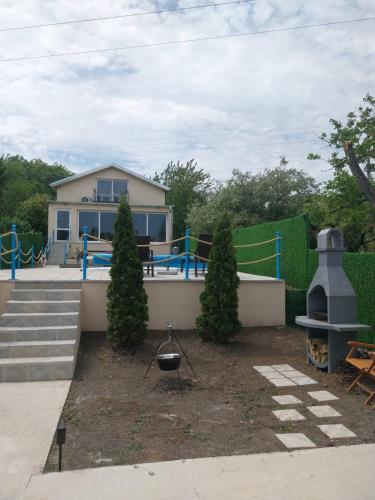 a house with a yard with a grill and trees at Olive garden house in Petrovaradin
