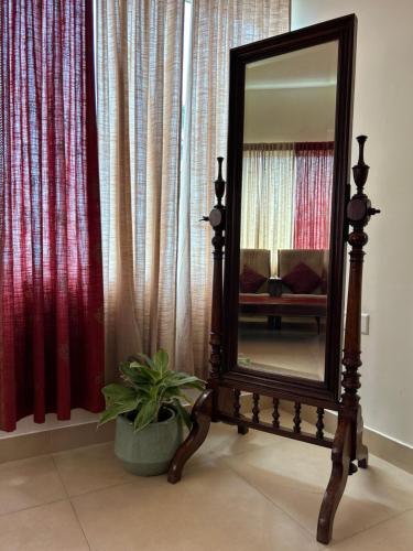 a mirror on a stand in a room with a plant at Santa Maria - A Premium Boutique Homestay by the Sea I Trivandrum Airport 1mile in Trivandrum