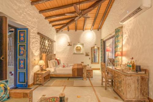 加尔加Paatlidun Safari Lodge, Jim Corbett的房间里有一张床和一张桌子的卧室
