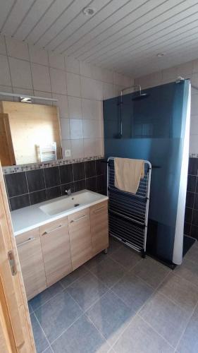 une salle de bain avec une baignoire, un lavabo et un miroir dans l'établissement Gîte des flocons, à Morbier