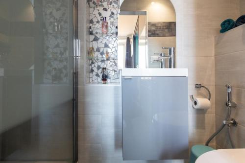 La salle de bains est pourvue d'une douche et d'un réfrigérateur blanc. dans l'établissement Charmant appartement à 5min du Palais des Festivals, à Cannes