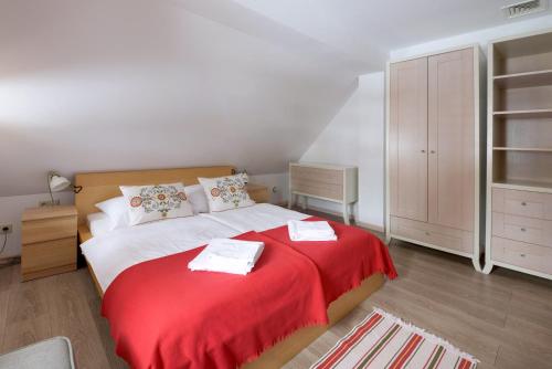 a bedroom with a large bed with a red blanket at Dom Nad Wodospadem pod Śnieżnymi Kotłami in Jelenia Góra-Jagniątków
