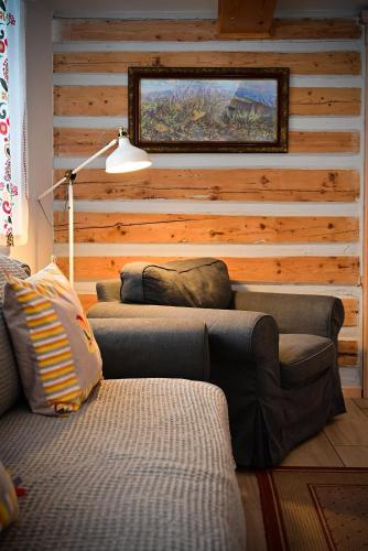 a living room with a couch and a wooden wall at Dom Nad Wodospadem pod Śnieżnymi Kotłami in Jelenia Góra-Jagniątków