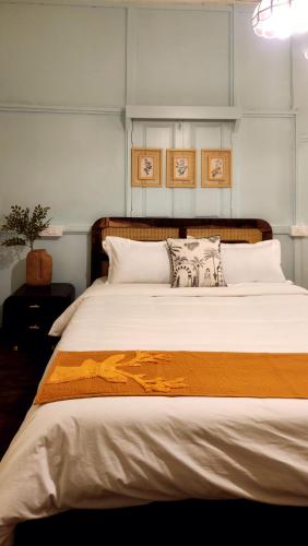a bedroom with a large bed with two pictures on the wall at Rococo by Concordia Hospitality in Shillong