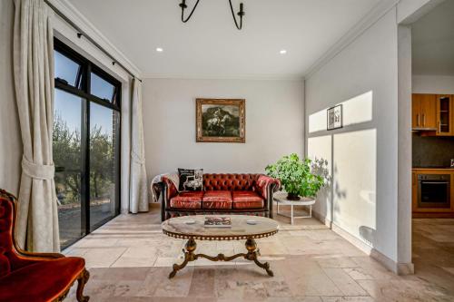 a living room with a red couch and a table at LIAPIS ESTATE Rostrevor Adelaide in Adelaide
